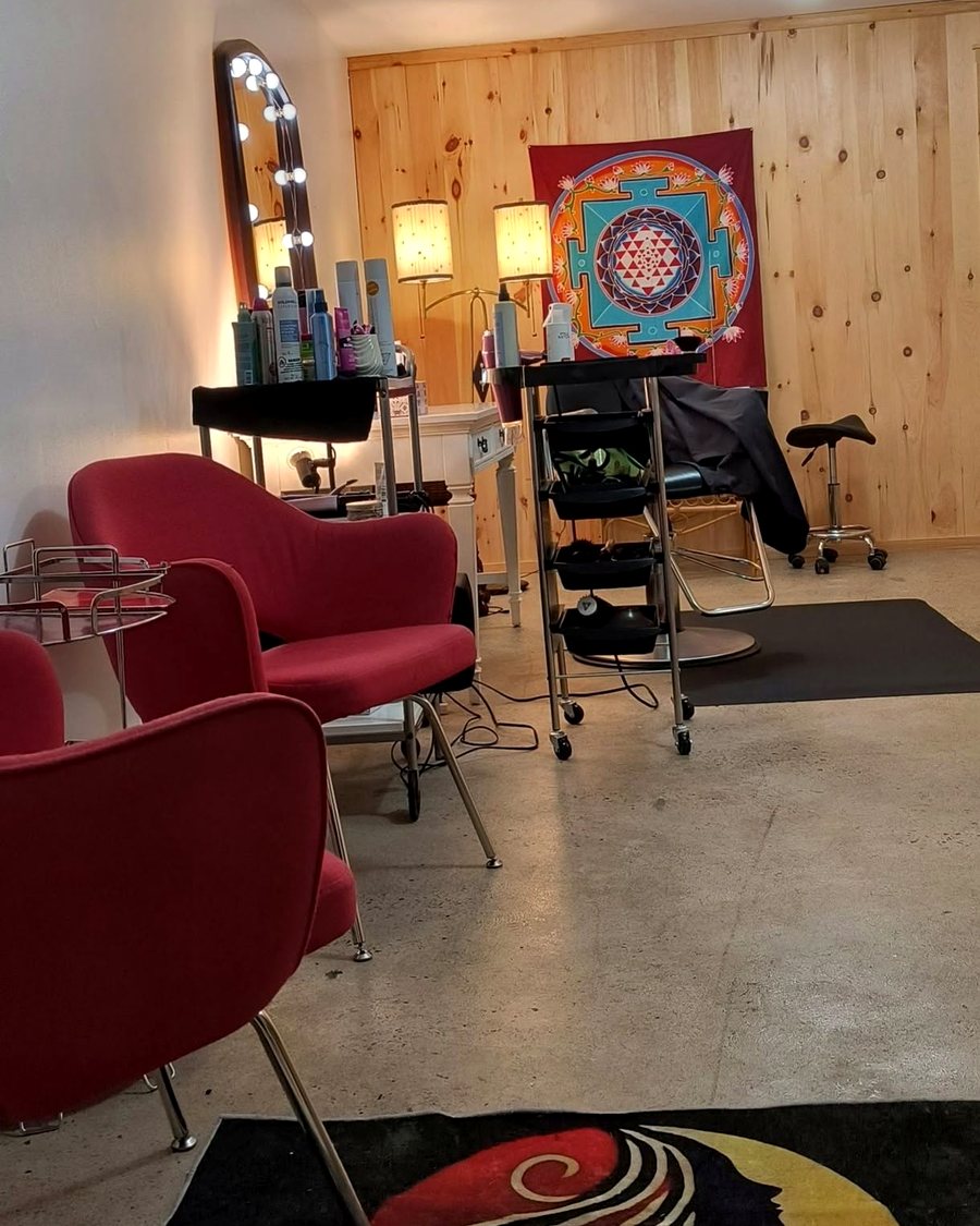 Le salon : miroir lumineux, fauteuils rouges et murs de pin